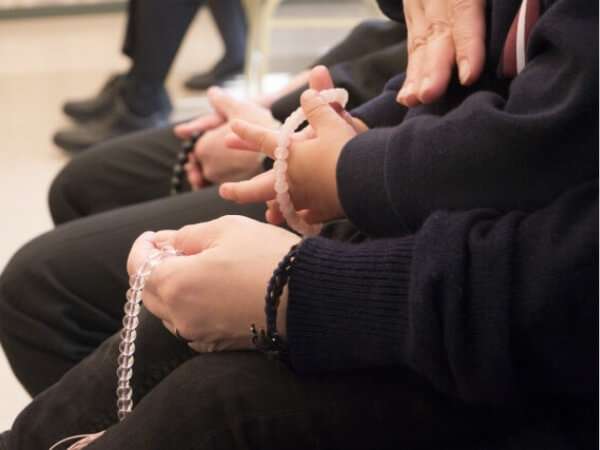 数珠の貸し借りをする人達